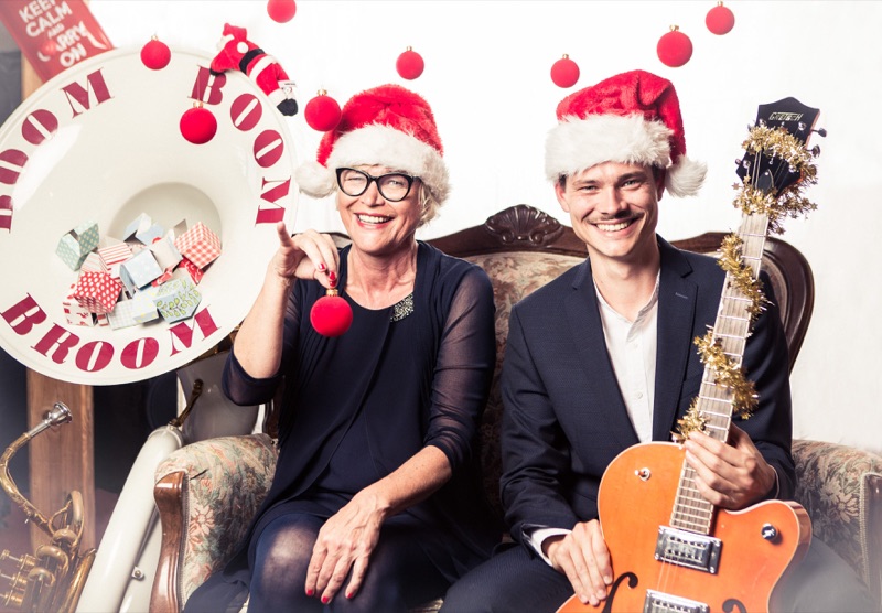 Heike Besen und Julius mit Nikolausmützen, Weihnachtskugeln und einer mit Lametta geschmückten Gitarre.
